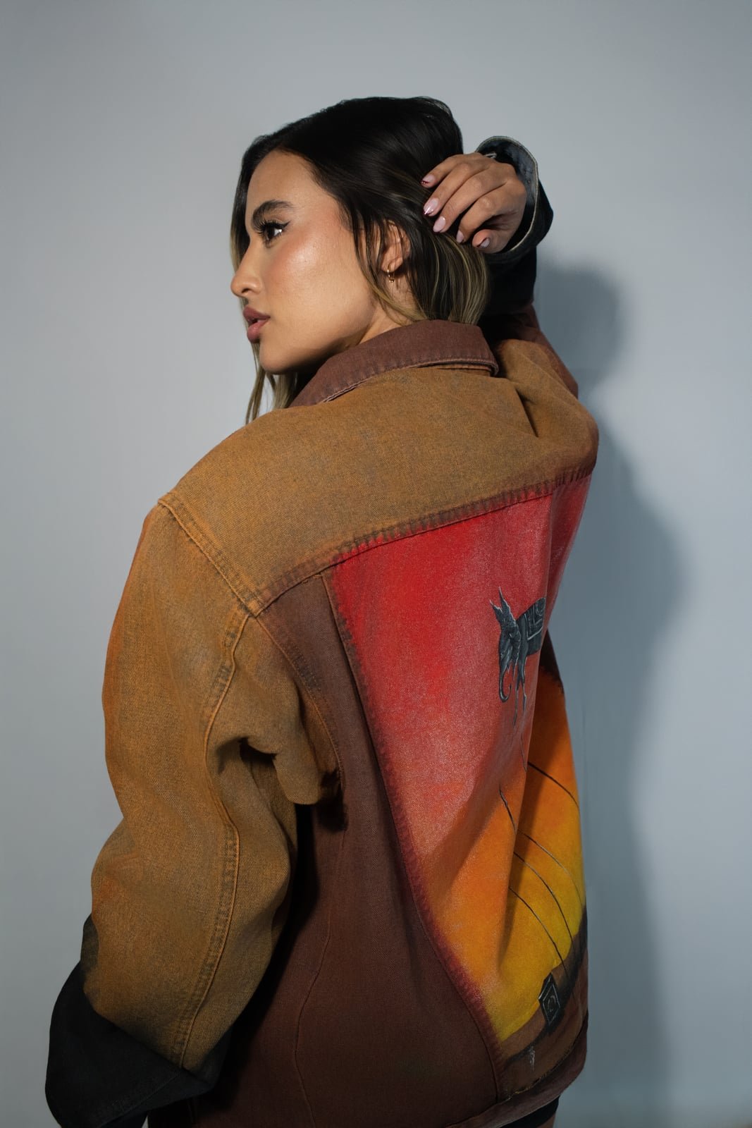 Model wearing a hand painted SarArt jacket in an urban setting
