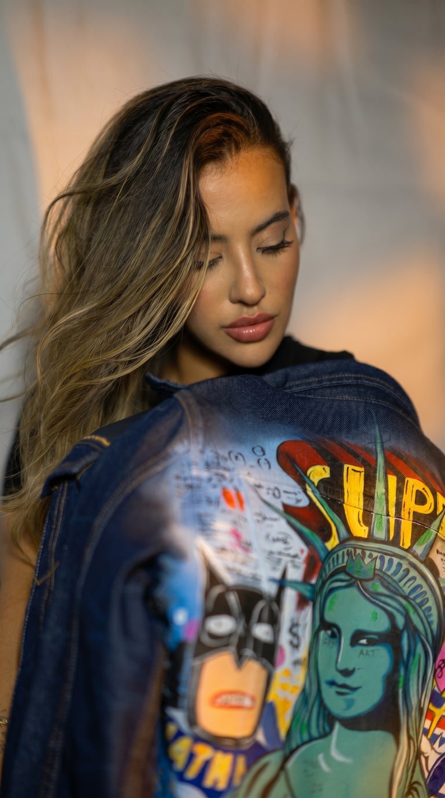Model wearing a hand painted SarArt jacket in an urban setting